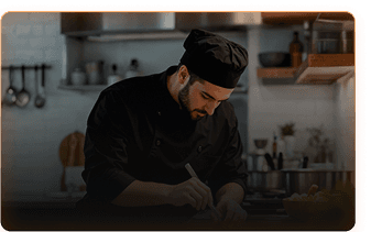 Professional chef in black uniform working in kitchen